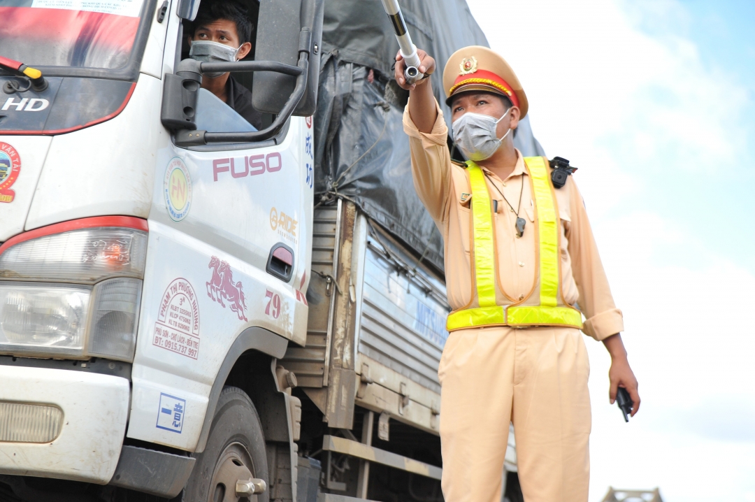 Lực lượng CSGT hướng dẫn xe vận tải hàng hóa có dán mã QR Code (luồng xanh) ưu tiên qua Chốt kiểm soát phòng, chống dịch COVID-19 trên Quốc lộ 14 đoạn qua xã Hòa Phú (TP. Buôn Ma Thuột).