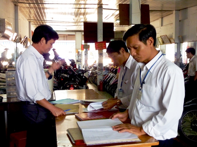 Cán bộ Chi cục Thuế thị xã Buôn Hồ kiểm tra, hướng dẫn người nộp thuế ghi sổ sách kế toán tại trụ sở doanh nghiệp.