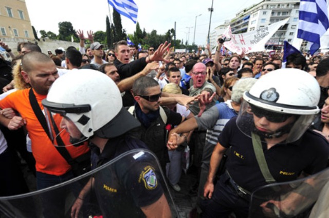 Cảnh sát chống bạo động ngăn cản đoàn người biểu tình trước tòa nhà Quốc hội ở thủ đô Athens. (Nguồn: Internet)