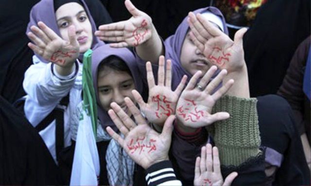 Học sinh Iran với dòng chữ ghi trên lòng bàn tay phản đối cuộc chiến nhằm vào quốc gia Hồi giáo này. (Nguồn: Internet)