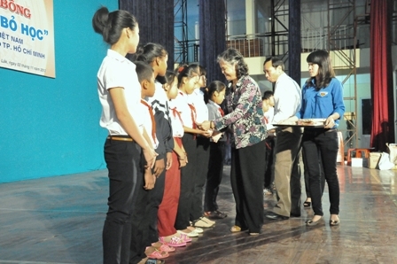 Đại diện ban tổ chức trao học bổng tặng các em học sinh nghèo trên địa bàn TP. Buôn Ma Thuột