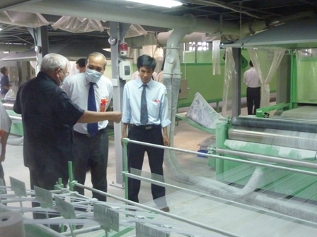 Phó Chủ tịch Thường trực UBND tỉnh YDhăm Ênuôl (giữa) tham quan dây chuyền sản xuất chỉ thun của Công ty Cổ phần Chỉ thun Dak Lak tại Khu CN Hòa Phú