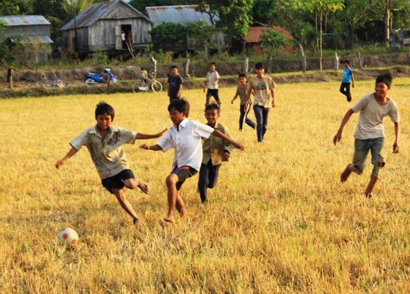 Trẻ em nông thôn còn nhiều thiếu thốn về mặt vật chất cũng như điều kiện vui chơi giải trí.  Trong ảnh: Sân chơi bóng đá của các em là cánh đồng sau mùa gặt.      Ảnh: H.G