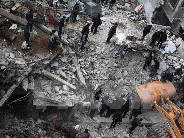 Tìm kiếm nạn nhân bị mắc kẹt trong đống đổ nát sau các cuộc không kích tại Douma, phía Đông thủ đô Damascus hôm 9-2-2015. (Nguồn: AFP/TTXVN)