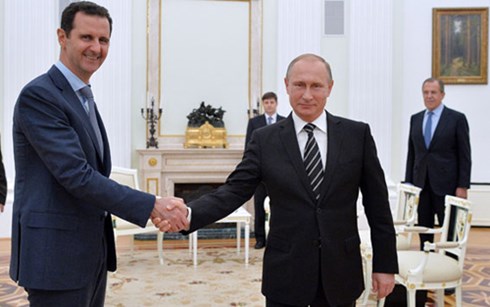 ổng thống Nga Vladimir Putin (phải) và Tổng thống Syria Bashar al-Assad bắt tay nhau tại Moscow ngày 21/10. (ảnh: TASS).