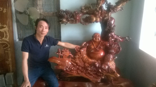 Anh Nguyễn Văn Hùng bên một tác phẩm của mình. 