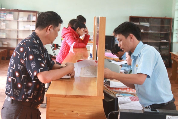 Cán bộ Bộ phận tiếp nhận và trả kết quả xã Cư Ni (huyện Ea Kar) hướng dẫn, giải quyết hồ sơ thủ tục cho người dân.