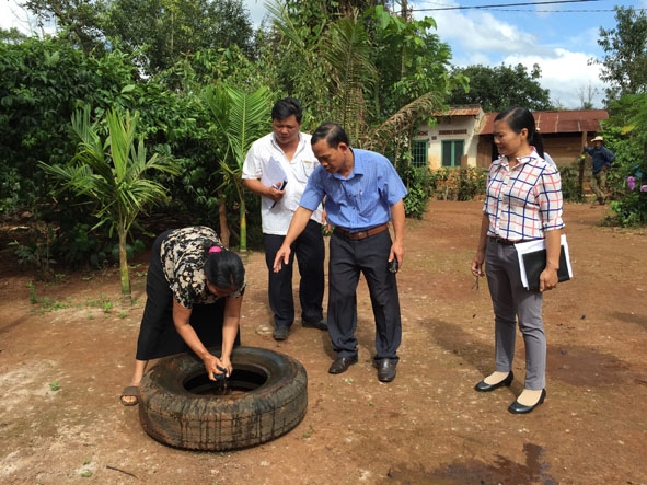 Cán bộ y tế hướng dẫn người dân xã Cư Suê xử lý lăng quăng (bọ gây).