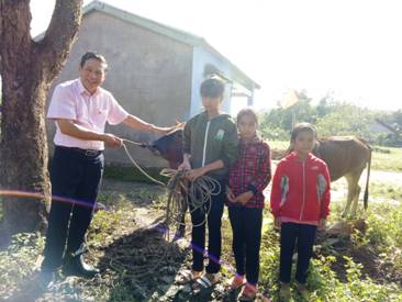 Lãnh đạo Ngân hàng Chính sách xã hội huyện M'Đrắk trao bò cho các cháu mồ côi do chị H'Lú Niê nhận nuôi. (Ảnh: Mỹ Sự)