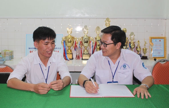 N' Ròng K'Duy Py (bìa trái) trao đổi công tác Hội với Chủ tịch Hội Sinh viên Trường Đại học Tây Nguyên.