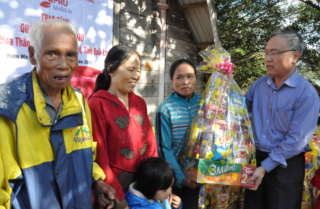 Tổng Biên tập Báo Đắ k Lắ k Nguyễn Văn Phú trao quà tặng các gia đình chính sách buôn Cuôr Kắp