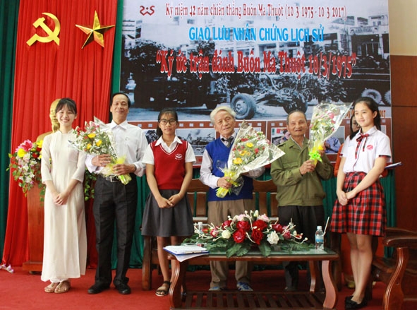 Các em học sinh trao hoa tặng các lão thành cách mạng tại chương trình giao lưu.  