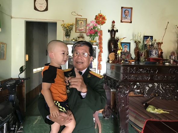Anh hùng Lực lượng Vũ trang nhân dân Phạm Huy Nghệ cùng cháu nội. 