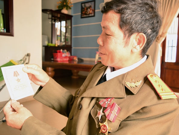 Ông Nguyễn Văn Bình và tấm Huân chương Bảo vệ Tổ quốc do Nhà nước Campuchia tặng. 