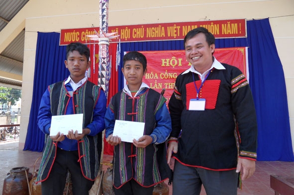(2)	Ông Nguyễn Văn Tâm trao thưởng cho các thí sinh đánh chiêng trẻ tại Hội thi Văn hóa cồng chiêng xã Cư Pui.