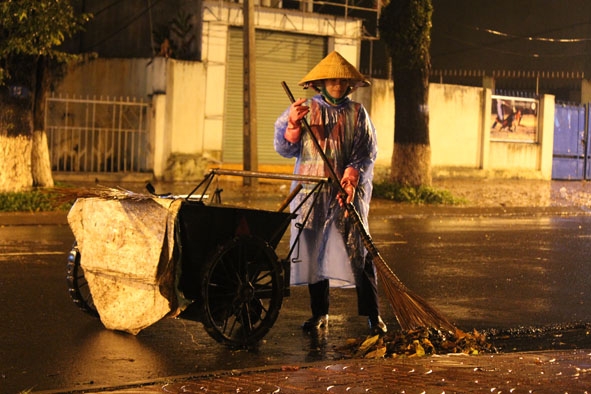Chị Lê Thị Hoài Vân quét rác trên đường Phan Chu Trinh dù trời mưa nặng hạt.