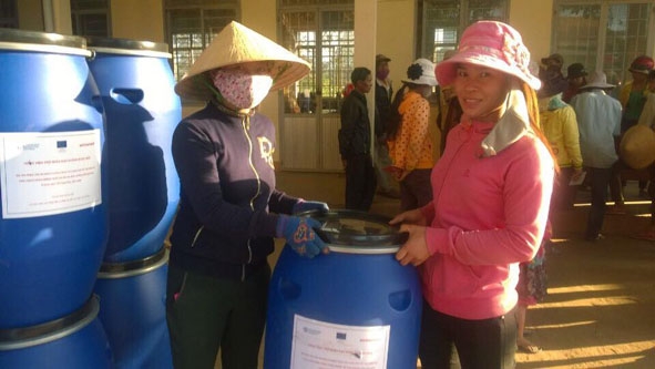 Người dân huyện Krông Bông nhận thùng nhựa Dự án hỗ trợ.