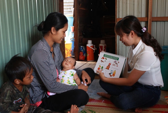 Cán bộ Trung tâm  Y tế huyện Ea Súp hướng dẫn bà mẹ  có con nhỏ trên địa bàn cách cho trẻ ăn đủ chất dinh dưỡng. 
