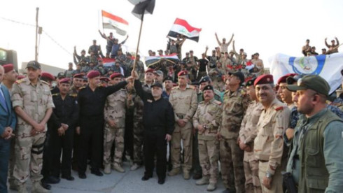 Thủ tướng Iraq Abadi vẫy quốc kỳ Iraq bên các binh sĩ Iraq tại Mosul. Ảnh: Twitter.