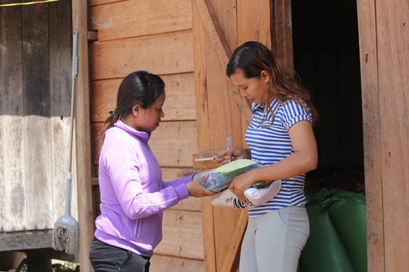 Chị H'Bốp phát bưu phẩm cho người dân ở xã Ea Trang. 