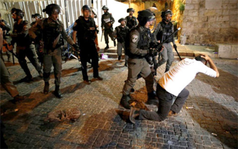 Cảnh sát Israel khống chế một người Palestine. (Ảnh: Reuters)