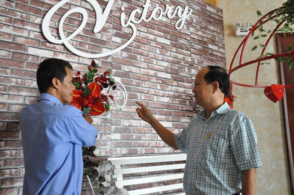 Ông Nguyễn Hữu Thành (bên phải) đang hướng dẫn nhân viên trang trí tại Nhà hàng Victory.  