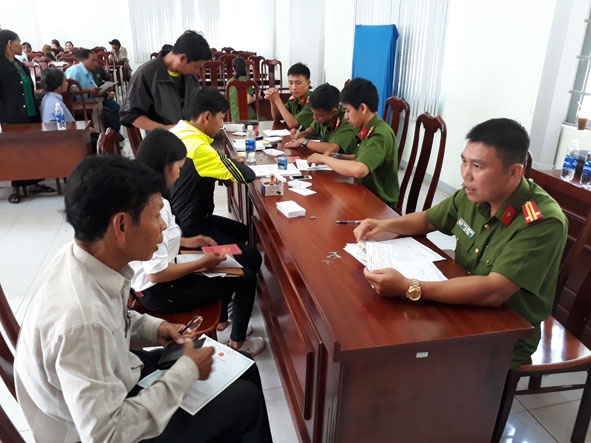 Cán bộ, chiến sĩ Công an  huyện Cư Kuin  làm thủ tục  cấp giấy khai sinh và CMND cho người dân  xã Ea Bhốk.  