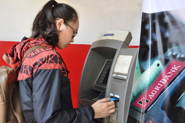Khách hàng giao dịch tại một trụ ATM của Agribank Đắk Lắk.  