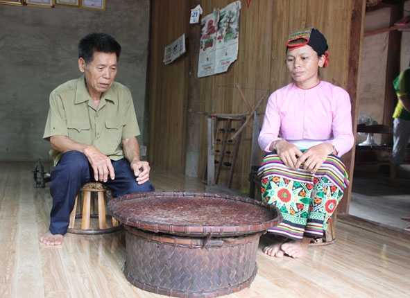 Cụ  Lang Văn Ọt  giới thiệu  các sản phẩm truyền thống  của  dân tộc Thái. 