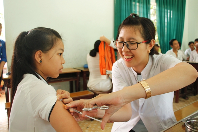 Nhân viên Trạm Y tế thị trấn Liên Sơn tiêm vắc xin viêm não Nhật Bản B cho học sinh Trường THPT huyện Lắk.
