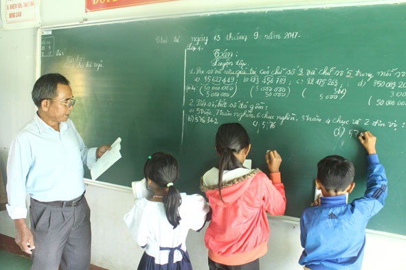 Thầy Y Lóa Kmăn đang dạy các em lớp học ghép ( 3 và 4) ở điểm trường buôn Py Pai Bi  thuộc Trường Tiểu học Y Ngông Niê Kđăm, xã Đắk Nuê, huyện Lắk. 