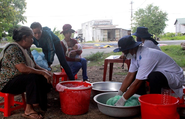 Cán bộ y tế tẩm màn bằng hóa chất phòng chống bệnh sốt rét cho người dân buôn Jang Lành, xã Krông Na.   