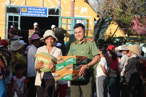 Đại diện Đoàn thanh niên Công an tỉnh trao quà hỗ trợ người dân xã Yang Mao sau bão số 12. 