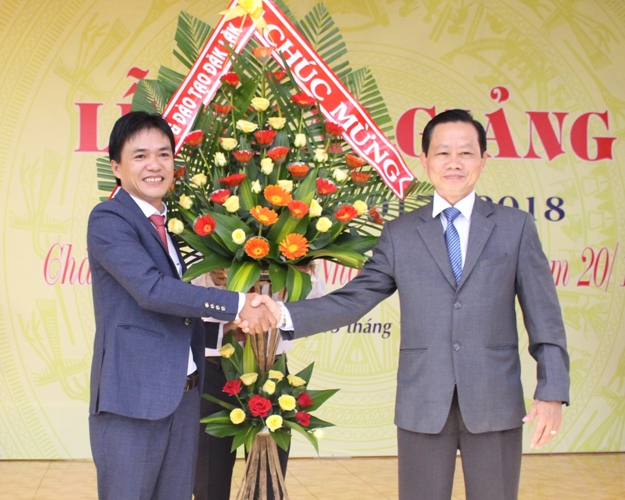 Phó Giám đốc Sở GD-ĐT Bùi Hữu Thành Cát (bìa phải) tặng lẵng hoa chúc mừng nhà trường. 