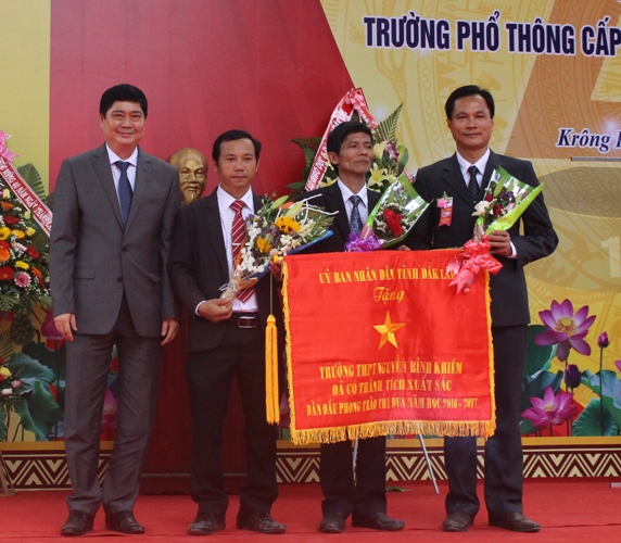 Giám đốc Sở GD-ĐT Phạm Đăng Khoa (bên trái) trao Cờ thi đua Đơn vị dẫn đầu phong trào thi đua năm học 2016-2017 của UBND tỉnh tặng nhà trường. 
