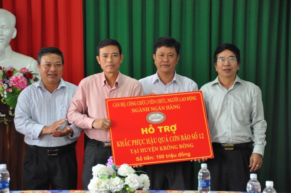 Giám đốc Ngân hàng Nhà nước Việt Nam Chi nhánh Đắk Lắk (bìa phải) Tăng Hải Châu  trao tiền hỗ trợ tại huyện Krông Bông. 