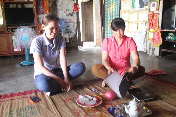 Chị Ngân (phải) trao đổi với cán bộ dân số xã Ea Bar về công tác dân số - KHHGĐ.