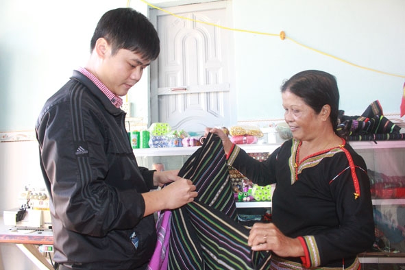 Bà H'Jih Ayun (bìa phải) đang giới thiệu sản phẩm dệt thổ cẩm. 