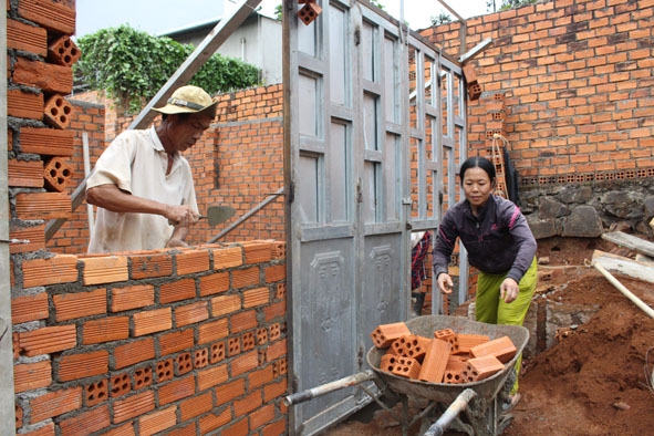 Chị Nguyễn  Thị Gái  đang phụ giúp xây dựng  để ngôi nhà  Đại đoàn kết  của gia đình  sớm hoàn thành.  