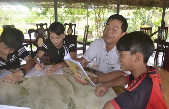 Thầy Trần Quang Thông kiểm tra việc học tập của các học sinh ở nhà lưu trú.   