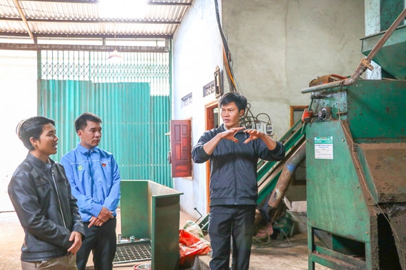 Anh Lê Quang Thi (bìa phải) giới thiệu quy trình hoạt động của hệ thống  máy chế biến cà phê quả tươi. 