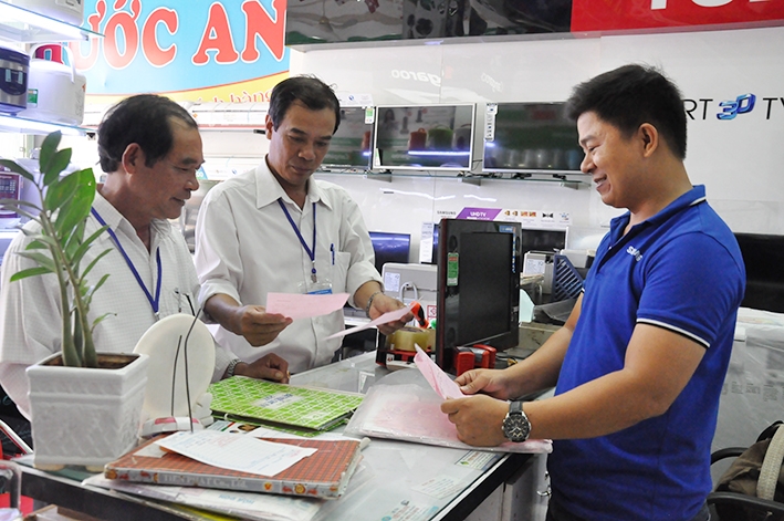 Cán bộ Chi cục Thuế huyện Krông Pắc kiểm tra hóa đơn, chứng từ tại một doanh nghiệp.