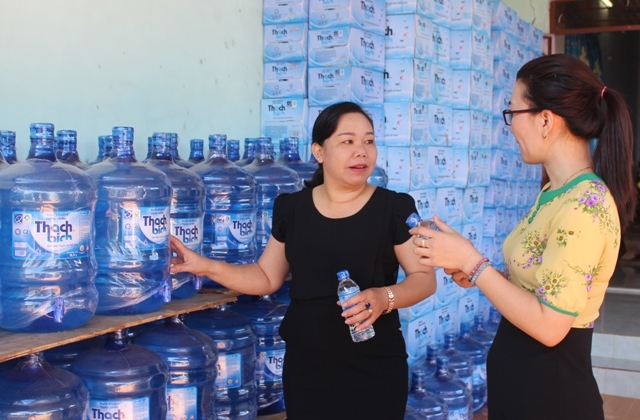 Chị Bế Thị Huế (bìa trái) giới thiệu sản phẩm nước uống tinh khiết.