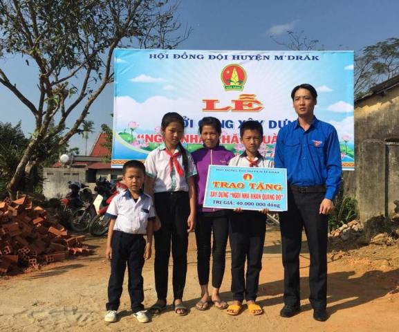 Đại diện Huyện Đoàn M’Đrắk trao biểu trưng ngôi nhà “khăn quàng đỏ” tặng gia đình học sinh khó khăn.