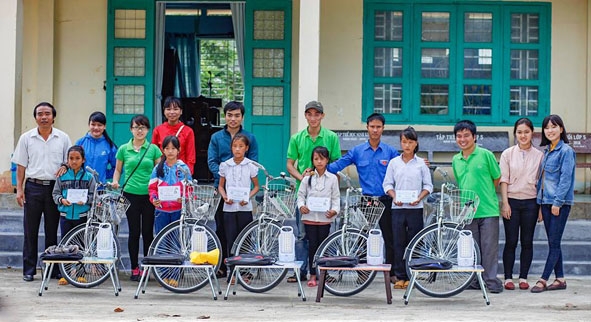 Đại diện Nhóm Vòng tay yêu thương  trao quà cho học sinh nghèo  tại huyện Krông Bông. 