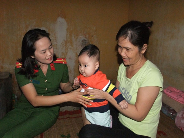 Trung úy Võ Thị Hiếu chăm sóc cho hai mẹ con bị can Ngô Thị Thanh Hương.