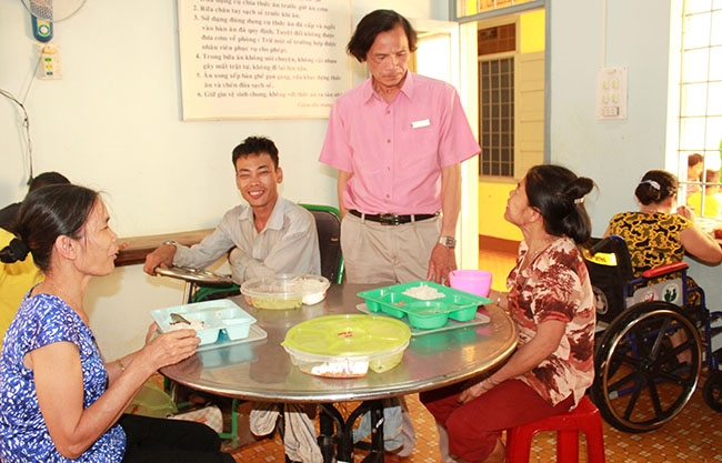Giám đốc Trung tâm Bảo trợ  xã hội tỉnh Nguyễn Quang Tuệ kiểm tra  bữa ăn trưa và  động viên các  đối tượng.  