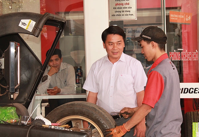 Anh Nguyễn Quang Vinh, Giám đốc Công ty TNHH Dịch vụ và Vận tải Tín Nghĩa trao đổi với nhân viên về dịch vụ sửa chữa săm lốp của cửa hàng. 