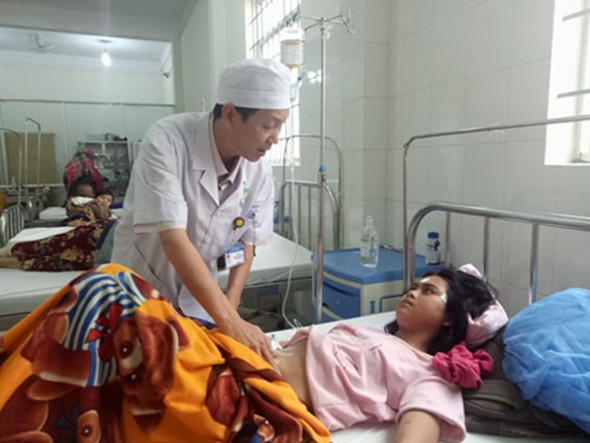 Bác sĩ Phạm Xuân Thủy đang khám cho bệnh nhân sau ca mổ.   