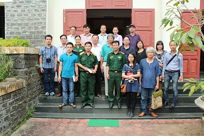 Ông Phạm Thành Công (áo trắng, đứng hàng giữa) chụp ảnh với khách tham quan Khu chứng tích Sơn Mỹ.  